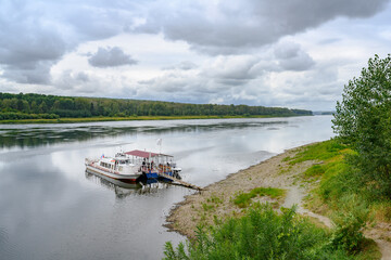 Fototapeta premium Berth with tourist ships under a stormy sky on the Tom River in Siberia