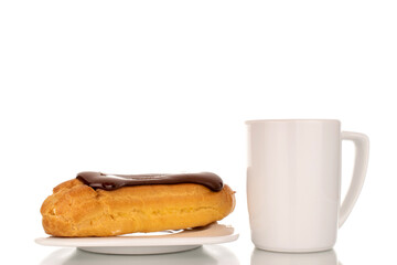 One sweet chocolate eclair on a white saucer with a cup, close-up, isolated on a white background.