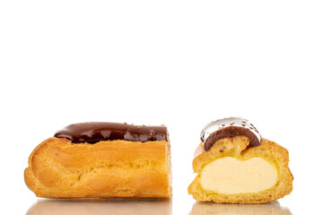 One sweet chocolate eclair cut in half, close-up, isolated on white.