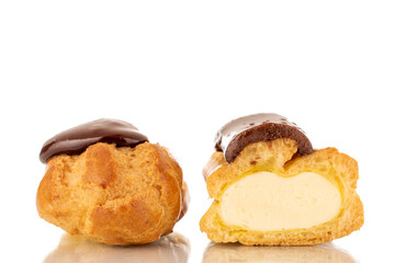 One sweet chocolate eclair cut in half, close-up, isolated on white background.