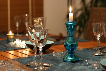Beautiful table setting with a candle on a wooden table.