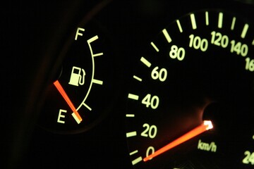 Closeup shot of a speedometer with a red arrow on 0. Out of gas concept.