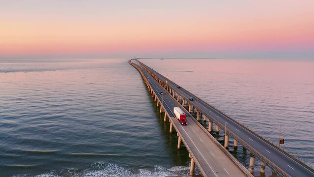 Aerial view of Chesapeake Bay Bridge Tunnel at sunset with forward camera motion. CBBT is a 17.6-mile bridge tunnel that crosses the mouth of the Chesapeake Bay.