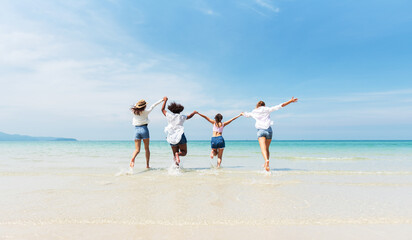 Holiday summer activity, Diverse teenage friends running into the sea. Group of friends playing on...