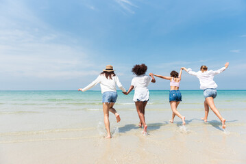 Holiday summer activity, Diverse teenage friends running into the sea. Group of friends playing on the beach. Lifestyles on vacation and holiday, Travel concept.
