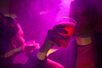 Woman and man drinking beer in a nightclub.