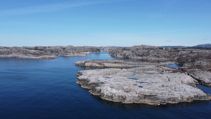 Fototapeta na wymiar Norwegian Sea. Rocks near the sea coast. Beautiful sea water. Blue sky and nice sun rays