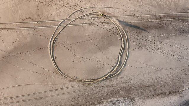 Motocross creating circle on the beach near the ocean