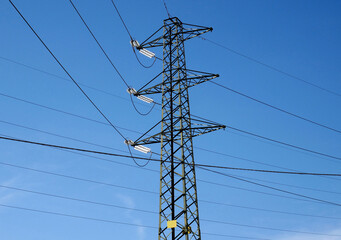 Electricity pylon with cables curving and changing direction at an intersection with other lines