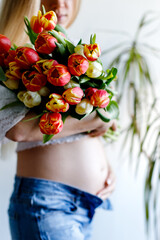 Fourth month of pregnancy. Beautiful pregnant woman with flowers. Concept of pregnancy, motherhood, mother's day.
