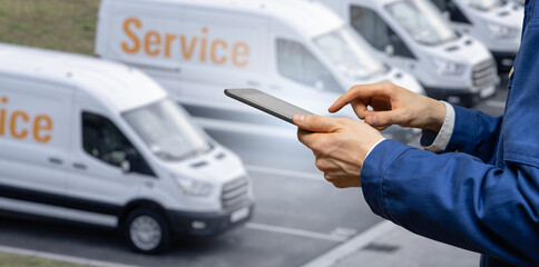 Manager with a digital tablet on the background of vans. Fleet management	