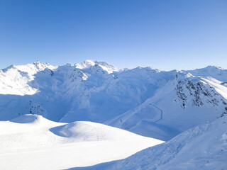 Panoramic view of French alpine rugged peaks covered with snow, with ski slopes . - 582224732