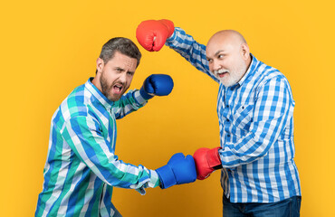 image of generation men disagreement. two generation men has disagreement isolated on yellow.