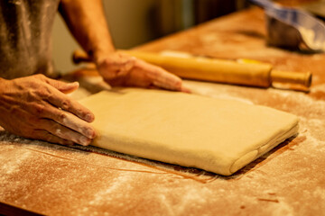 hombre amasando masa panadería repostería sobre mesada de madera