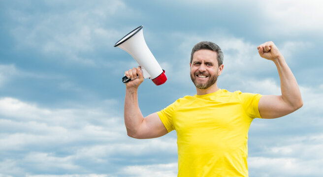 man in yellow shirt hold megaphone on sky background