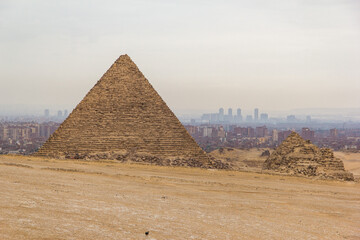 Fototapeta na wymiar The Great Pyramids of Giza with the hazy city of Cairo behind them.