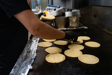 Chef at a mexican restaraunt grilling homemade tortillas on a hot grill