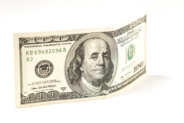 100 dollar bill stands on a white background.