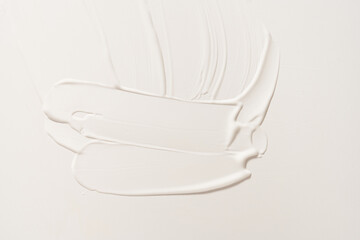 A white cosmetic smear on an isolated white background. Sample for advertising and packaging. The texture of a white face cream. Cosmetic skin care product with copy space. High quality photo