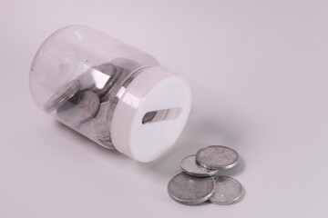 Coins in glass jar isolated on white background. Saving money concept.