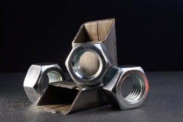 composition of nuts bolts and scraps of metal laid out on a dark background.