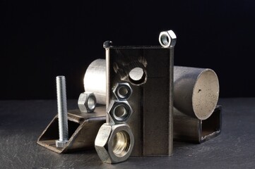 composition of nuts bolts and scraps of metal laid out on a dark background.