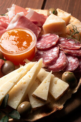 Tagliere con prodotti tipici della gastronomia italiana: salame, prosciutto crudo, pecorino,...