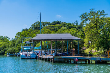 A view of a jetty and boats in a cove next to West Bay on Roatan Island on a sunny day