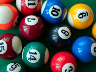 Colored billiard balls, close up. Striped and colorful balls on green table