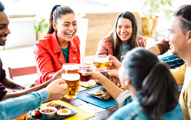 Trendy friends toasting beer and juices at business brunch venue - Food life style concept with young millenial friends enjoying happy hour time together at luxury terrace pub - Vivid contrast filter