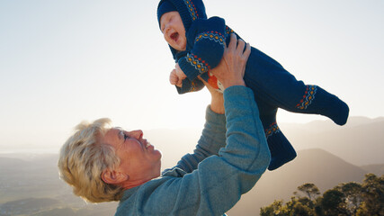 Elderly woman plays with infant baby outdoor