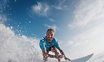 Happy surfer rides and smiles. Young man surfs the ocean wave in the Maldives and smiles