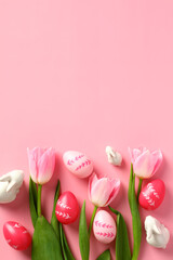 Fototapeta na wymiar Happy Easter concept. Easter poster design with colorful eggs, decorative bunnies and tulips on a pink background