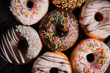 Colorful donuts on stone table. Top view with copy space.