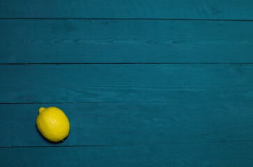 fresh lemon on a blue background with wood texture, place for inscription