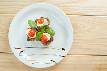 meat with cheese and tomato on a white plate