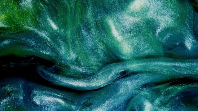 Shiny fluid motion. Glitter texture. Shimmering wave. Defocused blue purple green color sparkles flow holographic abstract background.