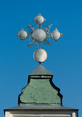 An old metal cross in an Orthodox monastery against a blue sky