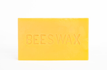 Front view of a brick of pure beeswax on a white background