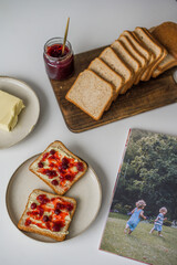 Bread with butter and cranberry jam is on the table and ready to eat. A delicious and sweet breakfast. Aesthetically pleasing serving of food. Recipe for toast with butter and jam.