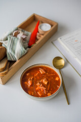 The traditional Ukrainian first course is red borsch. Hot borsch on the table with garlic, pepper, salt, onions and Ukrainian rye bread. Recipe for borsch with vegetables