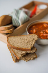 The traditional Ukrainian first course is red borsch. Hot borsch on the table with garlic, pepper, salt, onions and Ukrainian rye bread. Recipe for borsch with vegetables