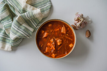 The traditional Ukrainian first course is red borsch. Hot borsch made of vegetables and pork on the table with garlic. Borsch recipe