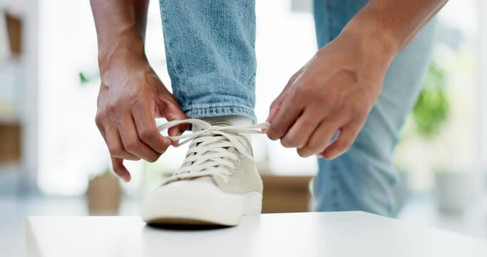 Hands, tie shoes and lace in home to get ready to start walking, travel or journey in house. Hand of man, person tying laces and sneakers, footwear or shoe in preparation for walk, trip or running.