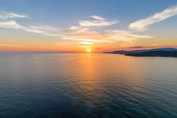 Naklejka premium aerial panorama of a calm ocean at sunrise. Aegean Sea at sunset with dramatic scenery. A cloudy sky is framed by orange and blue hues. Greece's Chalkidiki. Generative AI