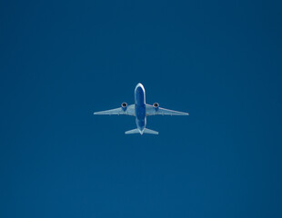 cockpit view of passenger Airplane in cruise flight in front of clear blue sky approaching with hight speed from ahead 