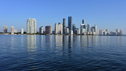 Fototapeta na wymiar Miami, Florida skyline reflected on calm Biscayne Bay in morning light on sunny clear day.
