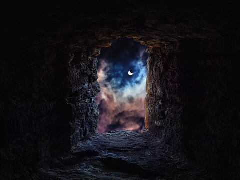 View from the castle loophole to the night cloudy sky with the m