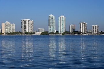 Residential towers reflected in calm water of Biscayne Bay in Miami, Florida on sunny clear morning.