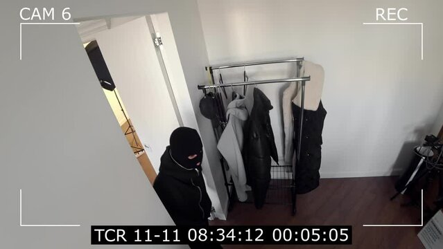 video surveillance systems. CCTV cameras record a burglar robbing a house.